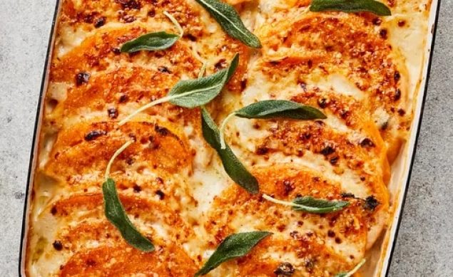 Gratin de potimarron au fromage avec des feuilles de romarin dans un plat allant au four