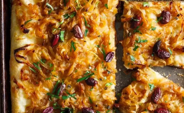 Tarte façon pissaladière avec une pâte à pizza, anchois, oignons et olives de Kalamata